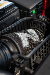 Nahaufnahme eines eingebauten Luftfilters mit N-Logo im Motorraum eines Autos. 1