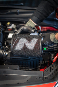 Mechaniker mit Handschuhen hält einen Luftfilter mit N-Logo 2