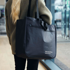 Ein Frau trägt eine schwarze Mercedes-Benz Truck Shopper Einkaufstasche 1