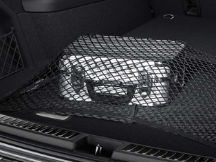 Silberner Koffer unter schwarzem Gepäcknetz