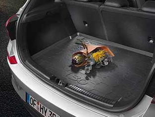 Schwarze Kofferraummatte mit abgelegten Blumen